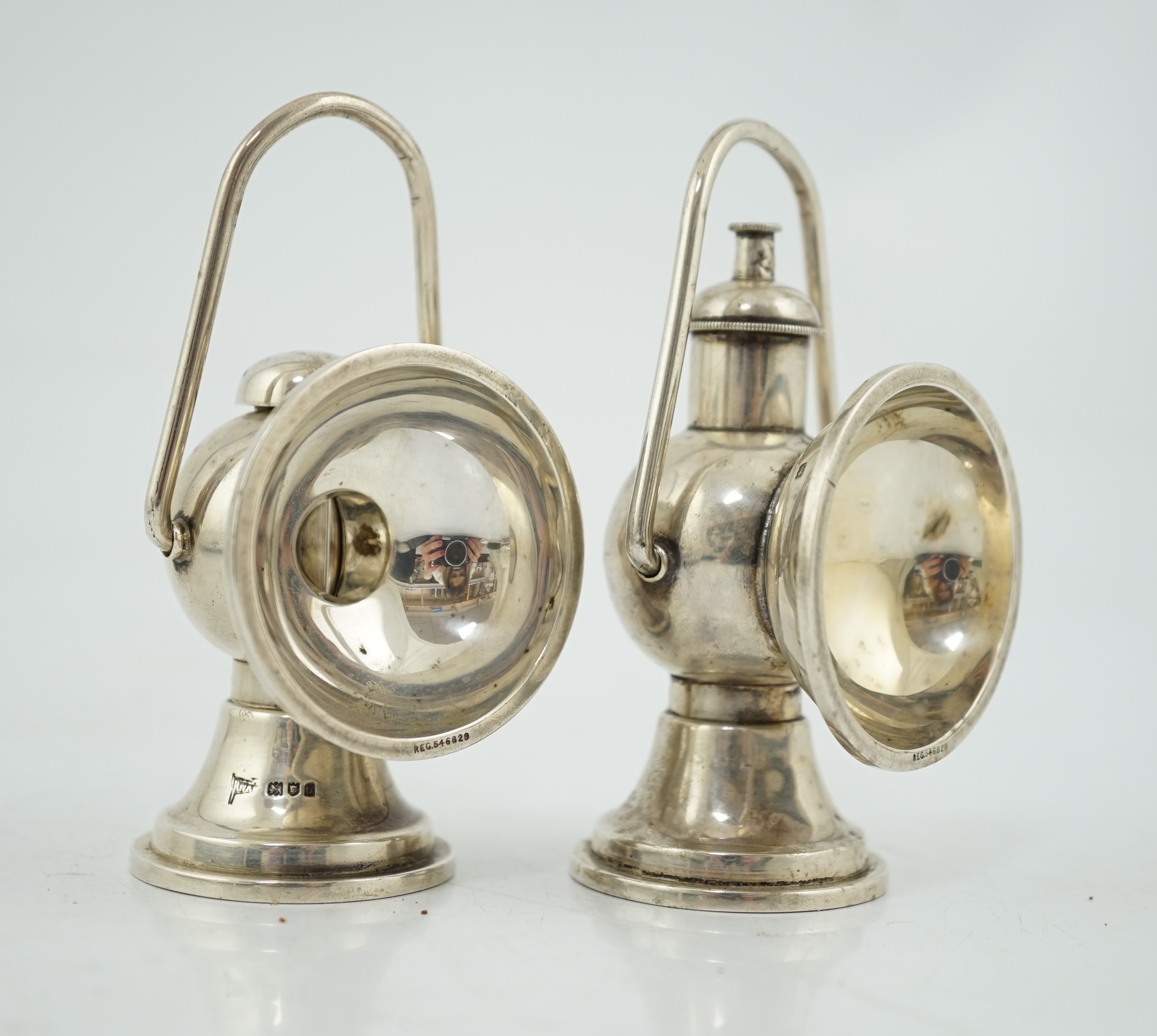An Edwardian novelty cigar cutter and perpetual lighter, modelled as a pair of railway lamps, by Walker & Hall